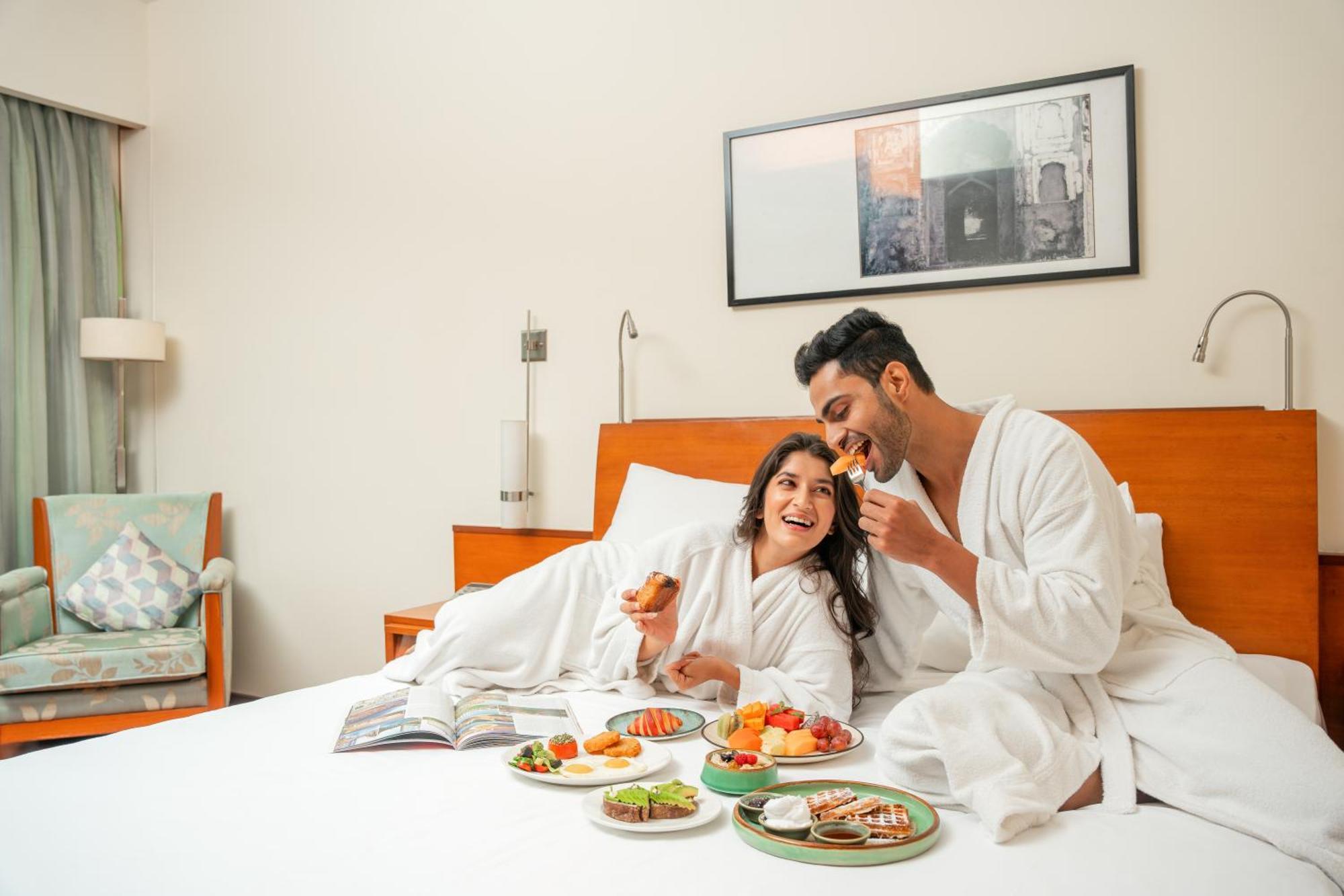 Hyatt Pune Exterior photo A couple eating breakfast in bed